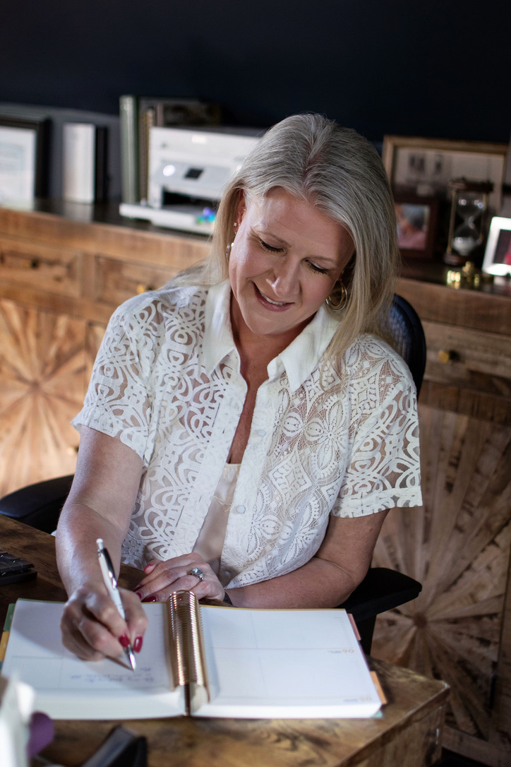 Lindy writing in an open notebook at her desk.